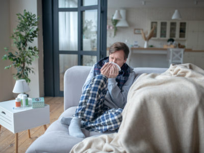 Businessman being on sick leave while having sneeze and cough